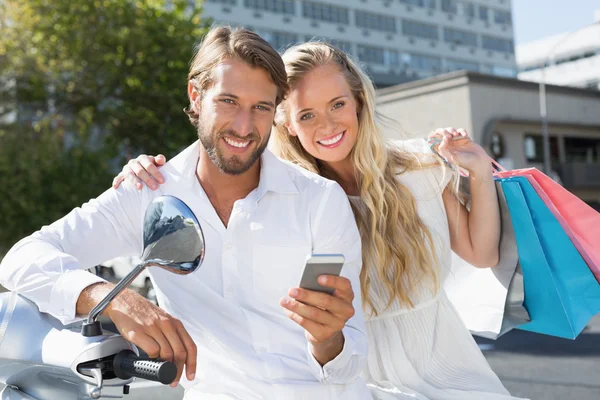 Attractive couple riding a scooter — Stock Photo, Image