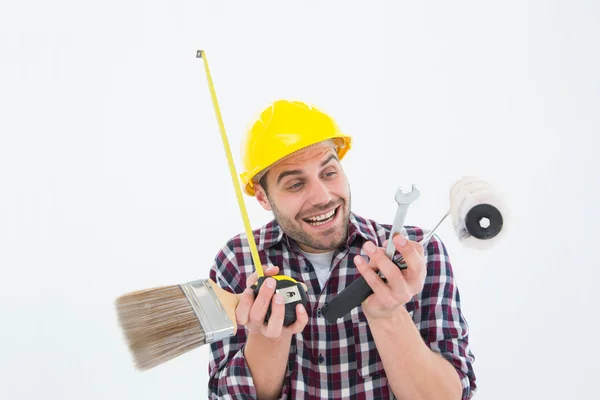 Reparador feliz segurando várias ferramentas — Fotografia de Stock