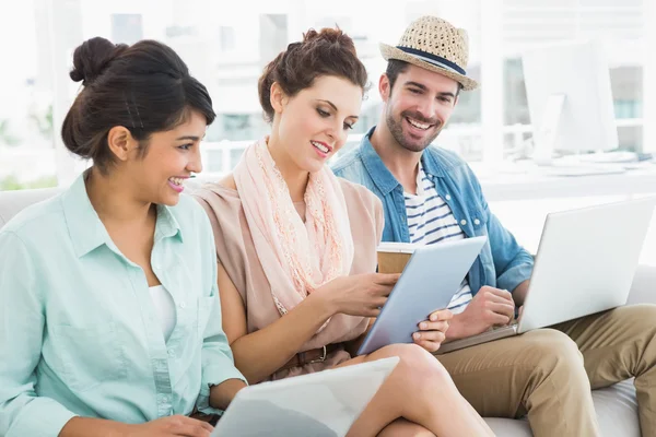 Colleagues using laptop and tablet on couch — Stock Photo, Image