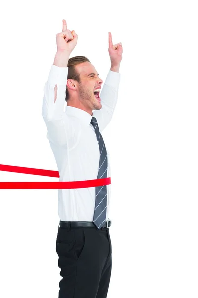 Happy businessman crossing the finish line and pointing up — Stock Photo, Image