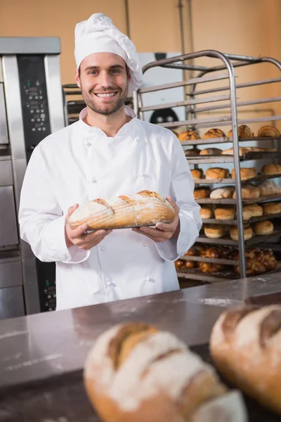 Taze pişmiş ekmek tutan Baker — Stok fotoğraf