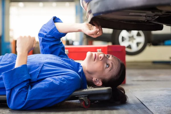 Mechaniker liegt und schaut unter Auto — Stockfoto