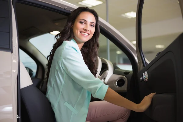 Усміхнена жінка сидить за кермом своєї нової машини — стокове фото