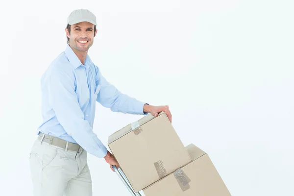 Uomo di consegna spingendo carrello di scatole — Foto Stock