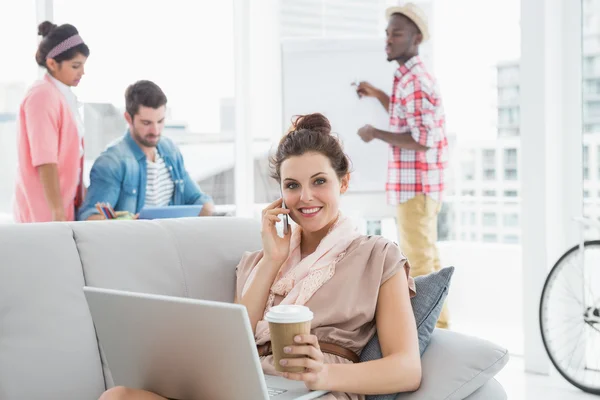 Mujer de negocios llamando por teléfono y utilizando el ordenador portátil — Foto de Stock