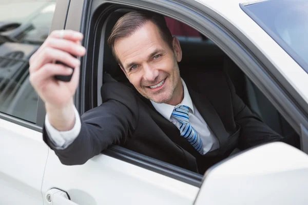 Empresário sorrindo e mostrando a chave — Fotografia de Stock