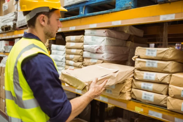 Lavoratore del magazzino che prende il pacchetto nello scaffale — Foto Stock