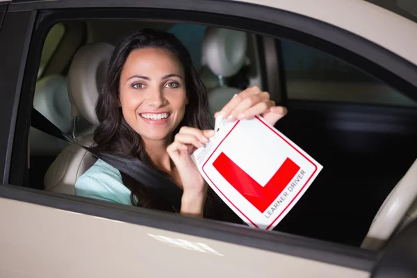 Cheerful female driver tearing up her L sign — Stock Photo, Image