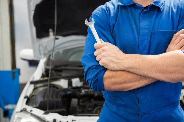 Mechanic holding wrench with crossed arms — Stock Photo, Image