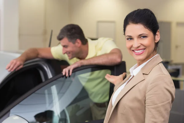 Empresária apresentando um carro a um cliente — Fotografia de Stock