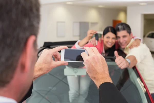 Geschäftsmann fotografiert Paar in neuem Auto — Stockfoto