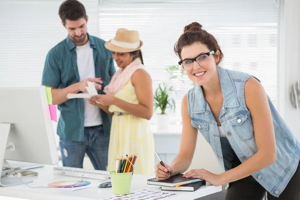 Woman taking note in front of colleagues — Stock Photo, Image