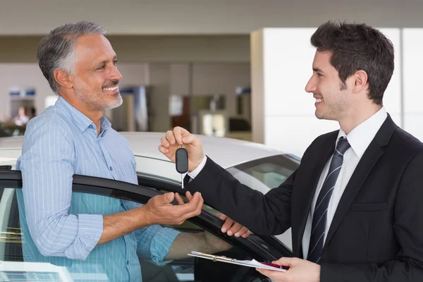 Homme d'affaires donnant la clé de voiture au client — Photo