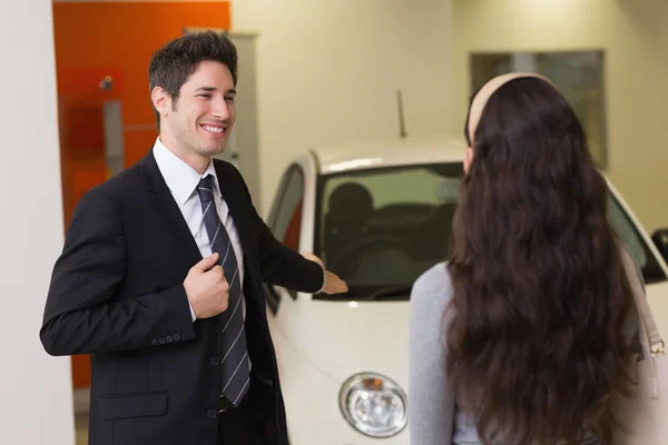 Affärsman som visar en bil till en kvinna — Stockfoto