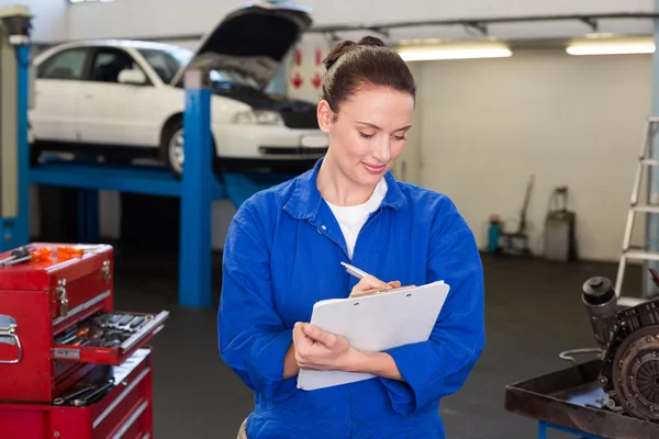 Mechanic writing on a clipboard — Stock Photo, Image