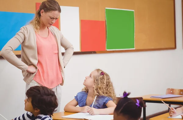 Angry teacher looking pupil with hands on hips — Stock Photo, Image