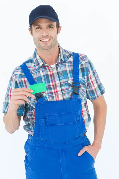 Confident plumber showing green card — Stock Photo, Image