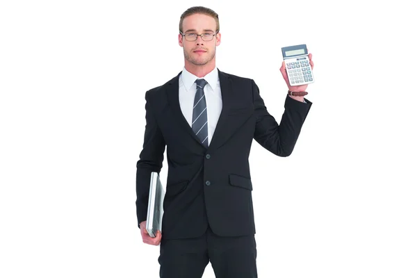 Serious businessman showing calculator holding laptop — Stock Photo, Image