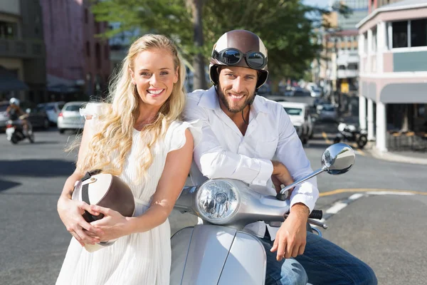 Attractive couple with their scooter — Stock Photo, Image