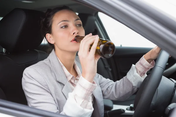 Mujer bebiendo cerveza mientras conduce — Foto de Stock