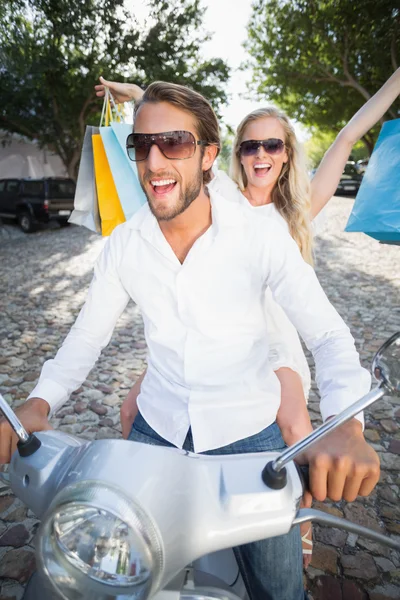 Attractive couple riding a scooter — Stock Photo, Image