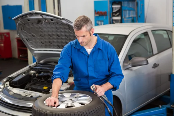 Focused mechanic inflating the tire — Stock Photo, Image