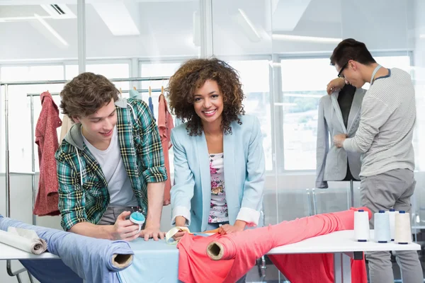 Estudiantes trabajando juntos con un tejido — Foto de Stock