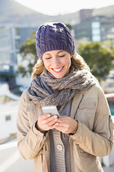 Blonde in warm clothes text messaging — Stock Photo, Image