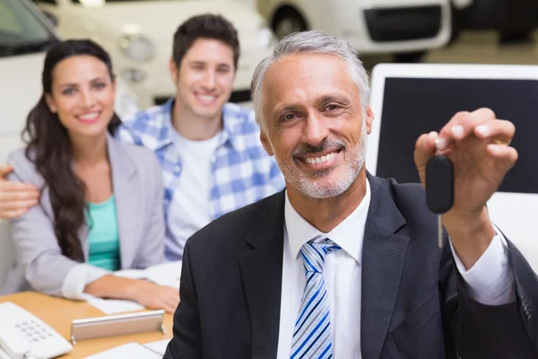Χαμογελώντας επιχειρηματίας δείχνει ένα κλειδί του αυτοκινήτου — Φωτογραφία Αρχείου