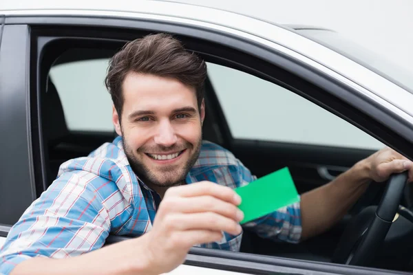 Joven sonriendo a la cámara mostrando la tarjeta —  Fotos de Stock