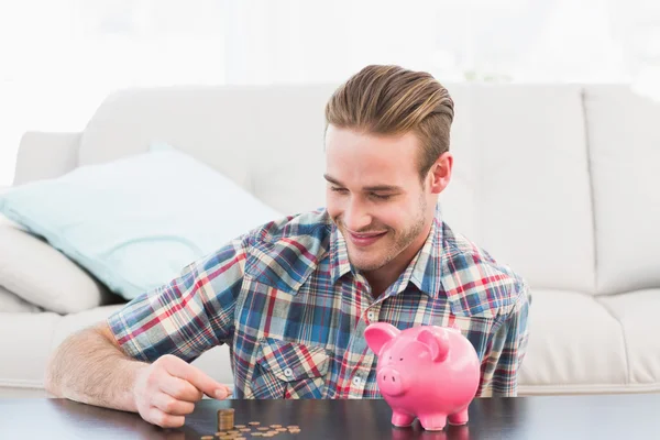 Uomo sorridente in possesso di un pennie — Foto Stock