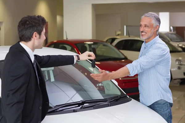 Businessman giving car key to customer — Stock Photo, Image