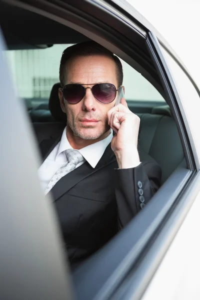 Homem de negócios ao telefone usando óculos escuros — Fotografia de Stock