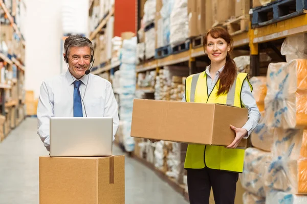 Gerente de almacén sonriente utilizando el ordenador portátil — Foto de Stock