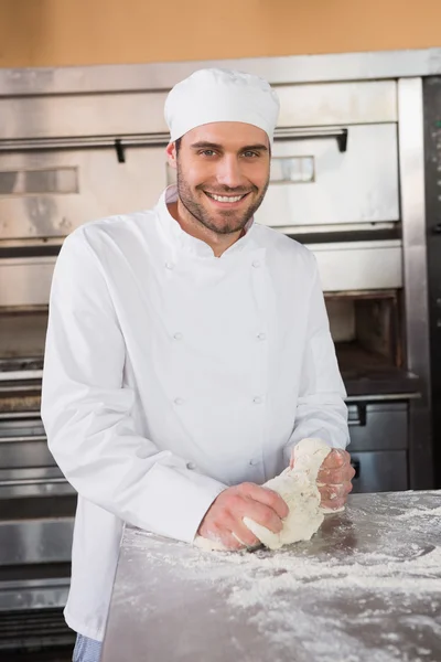 Baker kneading dough at counter — Stock Photo, Image