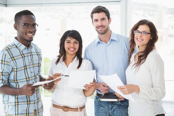 Collega's houden van bestanden en poseren glimlachen — Stockfoto