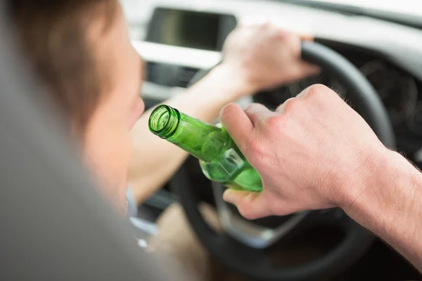 Hombre bebiendo cerveza mientras conduce — Foto de Stock