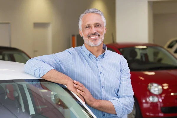 Cliente sonriente apoyado en el coche — Foto de Stock