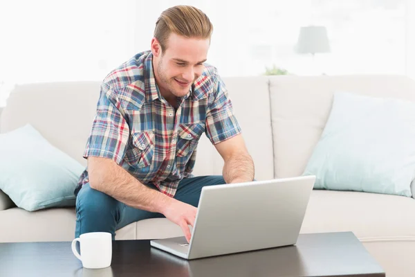 Uśmiechnięty mężczyzna w domu na laptopie — Zdjęcie stockowe