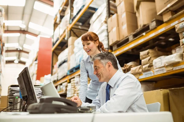 Warehouse managers working together on laptop — Stock Photo, Image