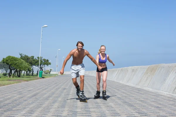 Par på rollerblades sammen på promenade – stockfoto