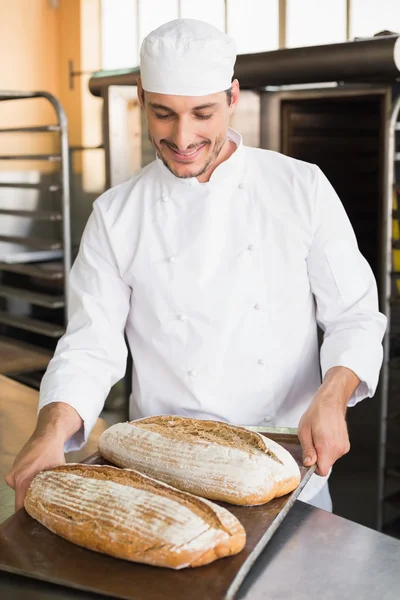 Baker bedrijf lade van vers brood — Stockfoto