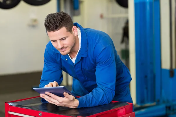 Smiling mechanic using his tablet — Stock Photo, Image