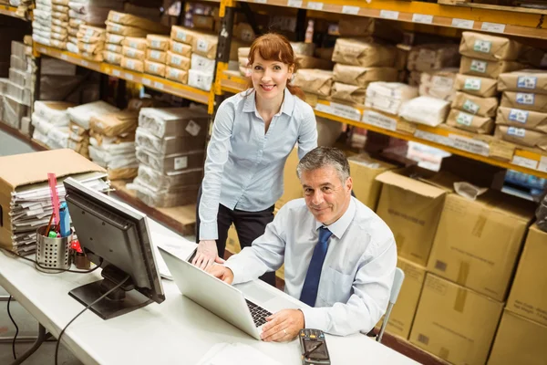 Warehouse managers working together on laptop — Stock Photo, Image