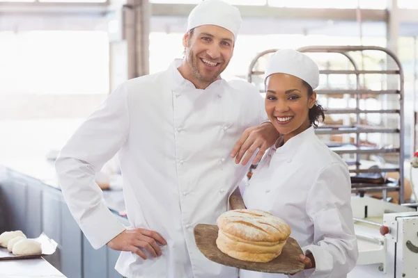 Team van bakkers lachend met brood — Stockfoto