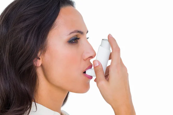 Astmatiska brunett med sin inhalator — Stockfoto