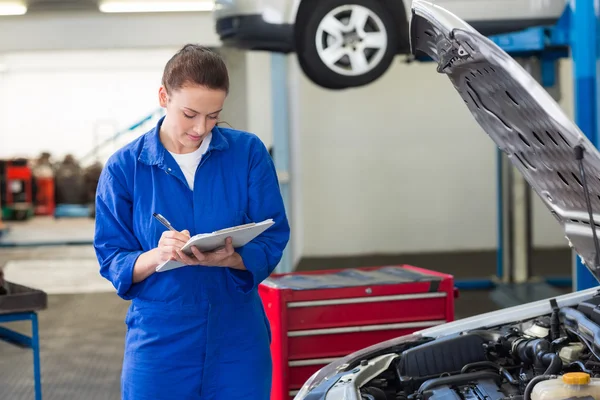 Mechanic examining under hood of car — Stock Photo, Image