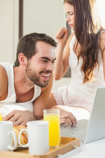 Jeune couple prenant le petit déjeuner au lit — Photo