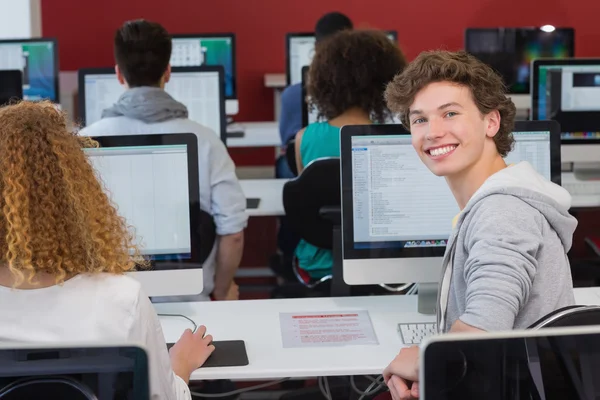 Student se usmívá na kameru v počítačové učebně — Stock fotografie