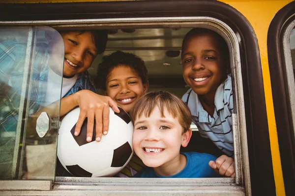 Carino alunni sorridente a fotocamera in il scuolabus — Foto Stock